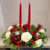 A beautiful table centerpiece with Christmas greens,  accented by seasonal flowers