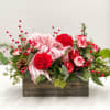 Red carnations, pine cones, ornaments, decorative ribbon, red berries, and fresh winter