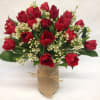 Vibrant red tulips are mixed with wax flower for a festive vase