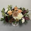 This winter arrangement features roses, hydrangea, snapdragons, stock, carnations, and chrysanthemums decorated