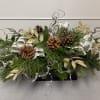 Decorate your table with a lovely holiday centerpiece featuring mixed evergreens, pinecones