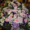 A mixture of white and lavender daisies, pink carnations, purple/blue iris, lavender