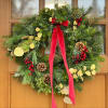 This fresh evergreen wreath is locally handmade and then accented with ribbon