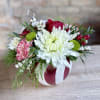 A cute ornament container with all red and white flowers and winter