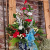 Designed in a blue ceramic snowflake container,
this arrangement is filled with red