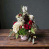 A festive mix of seasonal flowers in a ceramic birch bark container.