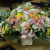 A mixture of white, lavender and yellow daisies, pink carnations, pink roses