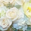 The arrangement includes a lovely mix of white seasonal flowers chosen by