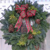 A classic Plaid Bow in a christmas green wreath with pinecones and