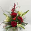 This festive arrangement showcases classic red roses, creamy blooms, winter greenery, and