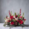 A beautiful centerpiece in gorgeous reds and holiday greenery, accented with pine