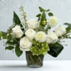 A fresh white-and-green arrangement of roses, dahlia, and hydrangea, artfully styled for