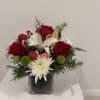 A joyful holiday arrangement featuring rich red roses, snowy white blooms, bright