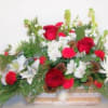Assorted flowers and roses mixed with fragrant holiday greenery in a modern