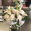 All white flowers in a cylinder vase 
roses, lilies, hydrangeas