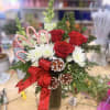 A cheerful holiday vase arrangement featuring classic red roses, white mums, frosted