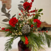 A beautiful fresh bouquet of holly, cedar and pine tips designed in