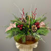A brown basket filled with a lush selection of assorted winter greens