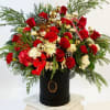 An extravagant Christmas design showcasing premium red roses, carnations, seasonal greens, and