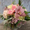 An elegant combination of hydrangea, roses, and a striking cymbidium orchid in