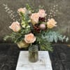 Peach roses, berries, snap dragons, eucalyptus, princess pine, cedar, and Carolina blue