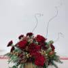 A wintery mix of red heart roses, berries and an assortment of