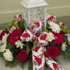 A CHARMING HOLIDAY CENTERPIECE FEATURING A RUSTIC WHITE LANTERN WITH SNOWFLAKE DETAIL