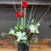 A striking holiday arrangement featuring bold red amaryllis, snowy white double lilies