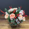 A beautiful peach garden rose arrangement complemented by lush ilex and presented