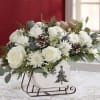 Beautiful sleigh arrangement with variety of Christmas greenery roses and more. 