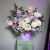 This boxed flower arrangement, enriched with pastel roses, lavender blooms, baby's breath