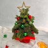 A festive mini Christmas tree designed with fresh evergreens, red and green