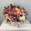 A luxury winter arrangement designed with mauve roses, peach garden roses, spray