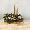 A classic holiday centerpiece crafted with evergreens, shimmering ornaments, cinnamon sticks, and