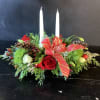 Long &amp; low centerpiece featuring taper candles, Christmas greens, seasonal flowers, pine