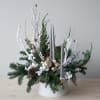 Fresh flower arrangement featuring pine and seasonal ornaments, and candles. Some items