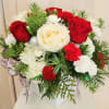 White ceramic vase with Christmas greens, red roses,  white snow roses