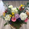 A vibrant garden-style arrangement overflowing with fresh white hydrangeas, pink gerbera daisies