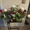 Mixed holiday greenery with ribbon, 12 red and white roses , lilies