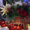 A holiday assortment of red and white flowers with seasonal greenery and