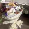 A beautiful hand-wrapped bouquet featuring a fresh mix of colorful blooms, including