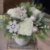 Lush white hydrangea is nestled among fragrant holiday greens and accented with
