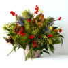 This stunning arrangement features a lush mix of winter evergreens, fragrant pinecones