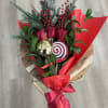 A festive holiday bouquet featuring rich red roses accented with fresh evergreen