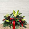 Slightly oblong centerpiece with a mix of hardy winter greens, bright red