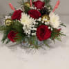 A festive blend of red roses, baby&rsquo;s breath, Christmas candies, and golden