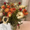 A sweet yet sophisticated arrangement of honey-toned roses, soft ivory blooms, and