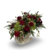 A classic holiday arrangement filled with deep red roses, textured green blooms