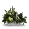 A serene winter arrangement featuring fresh evergreens, soft green blooms, berry accents