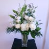 A beautiful design of crisp white roses, lisianthus, hydrangea and more amongst